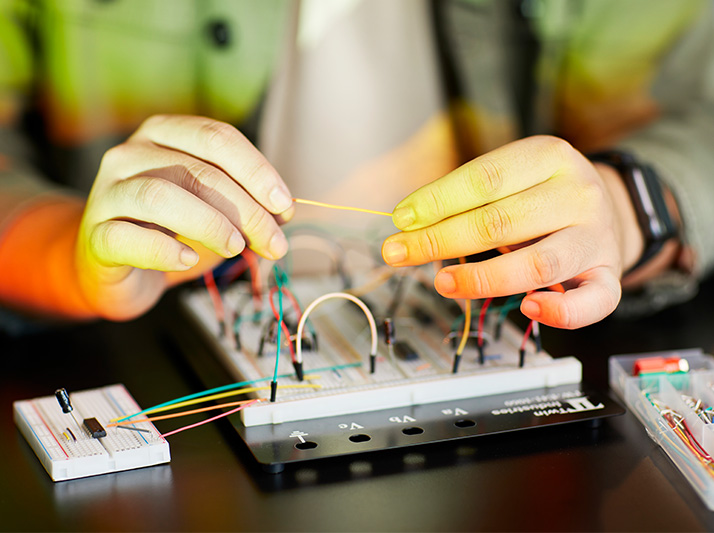 photo of hands working on circuit board